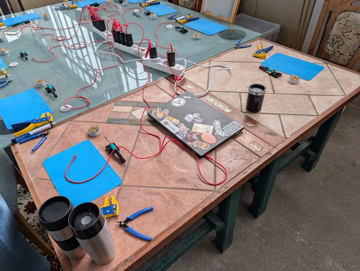 ein Tisch mit aufgebauten Löt-arbeitsplätzen