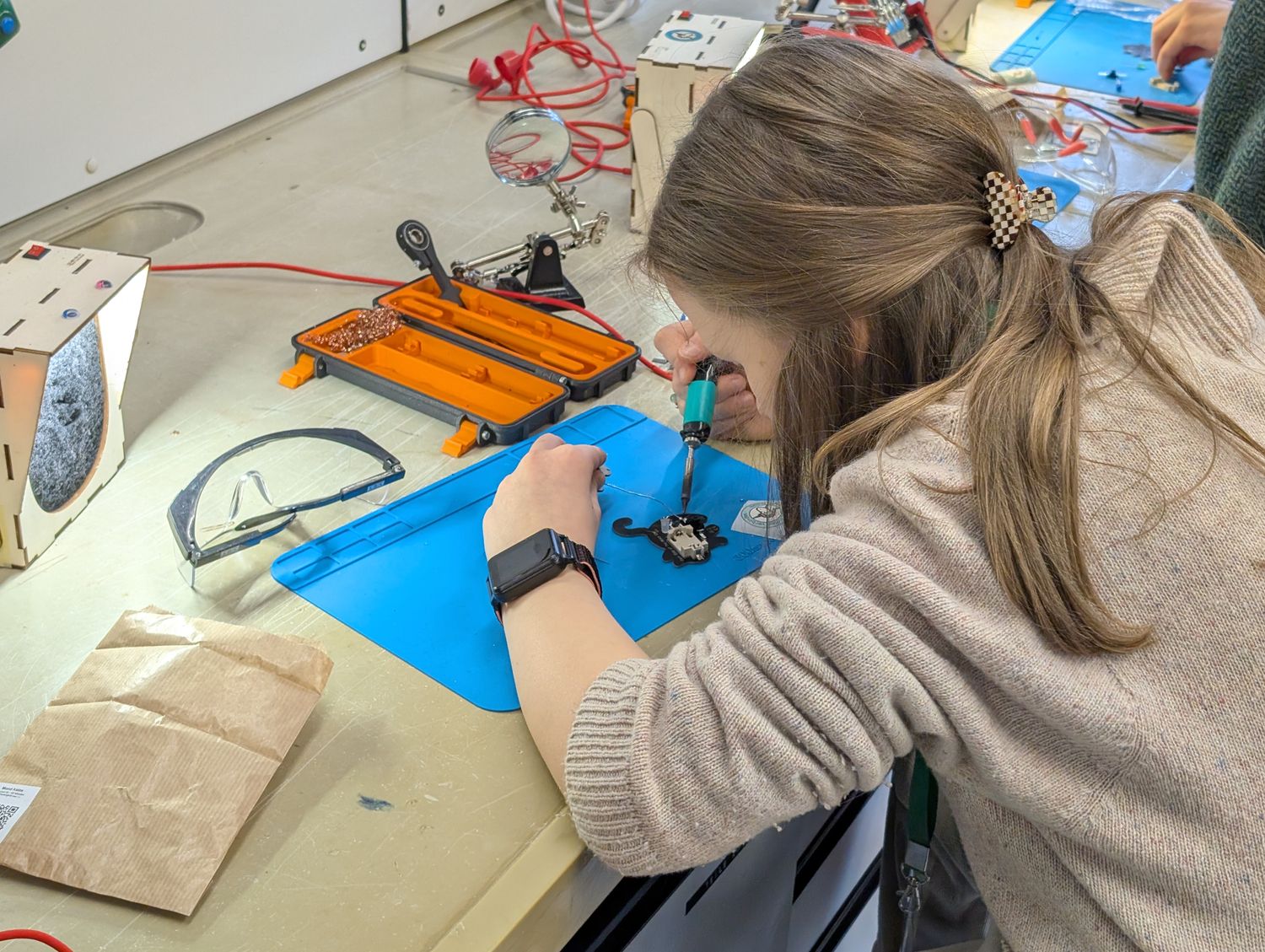 Löt-arbeitsplatz, an dem ein Kind eine Katze lötet